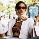 A stylish woman sits at an outdoor cafe