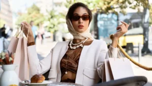 A stylish woman sits at an outdoor cafe