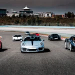 A group of sports cars races down an empty track