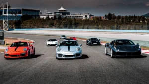 A group of sports cars races down an empty track