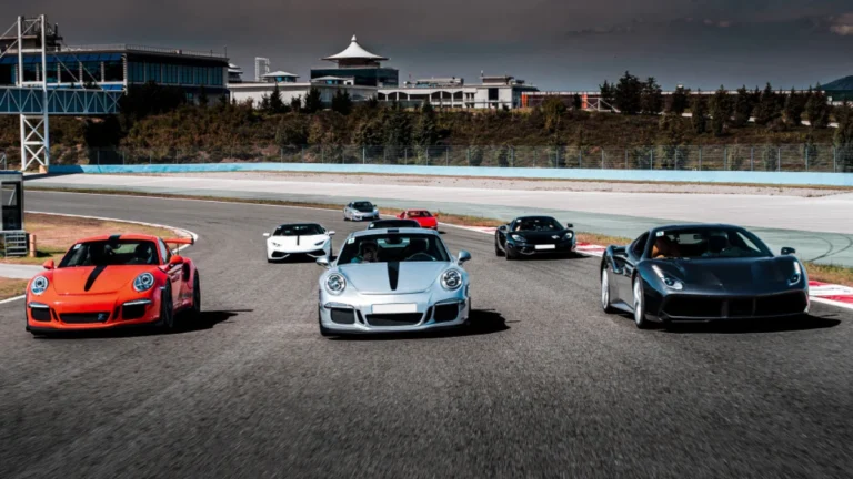 A group of sports cars races down an empty track