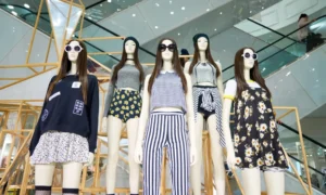 Five mannequins in trendy outfits, mall background