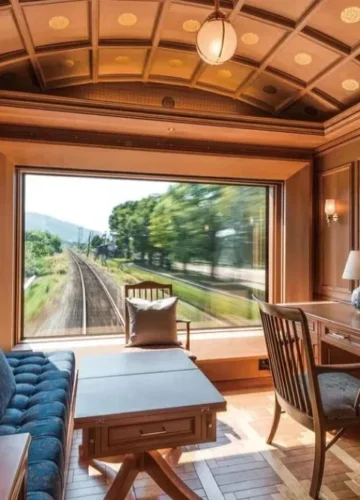 Luxurious train cabin with large window overlooking tracks