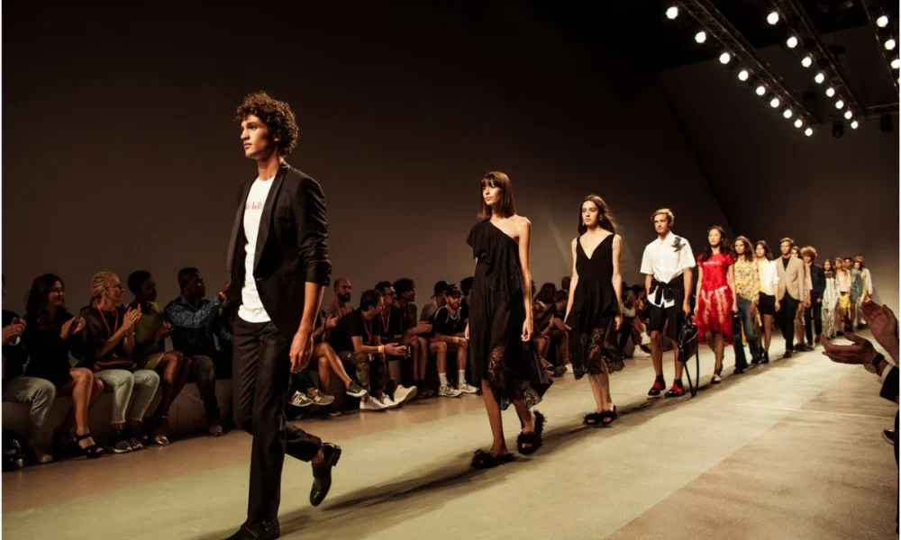 Models walk runway, audience claps