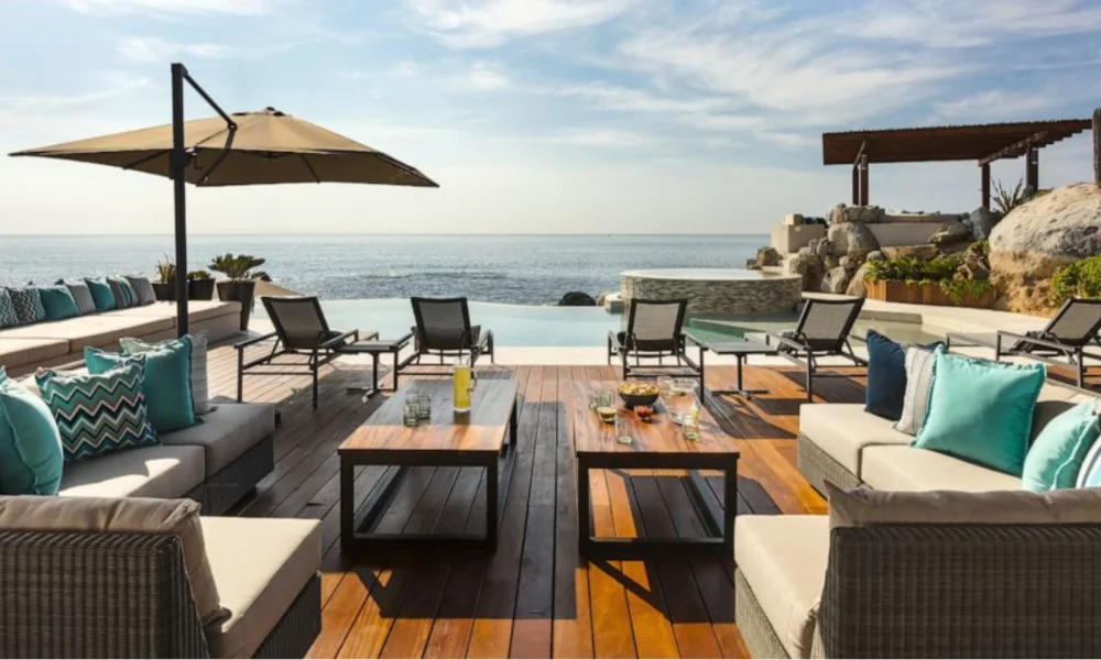 Oceanfront patio with infinity pool, lounge chairs, and outdoor seating
