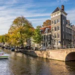 Amsterdam canal with boat, bridge, buildings