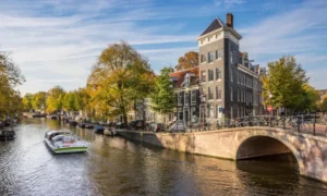 Amsterdam canal with boat, bridge, buildings