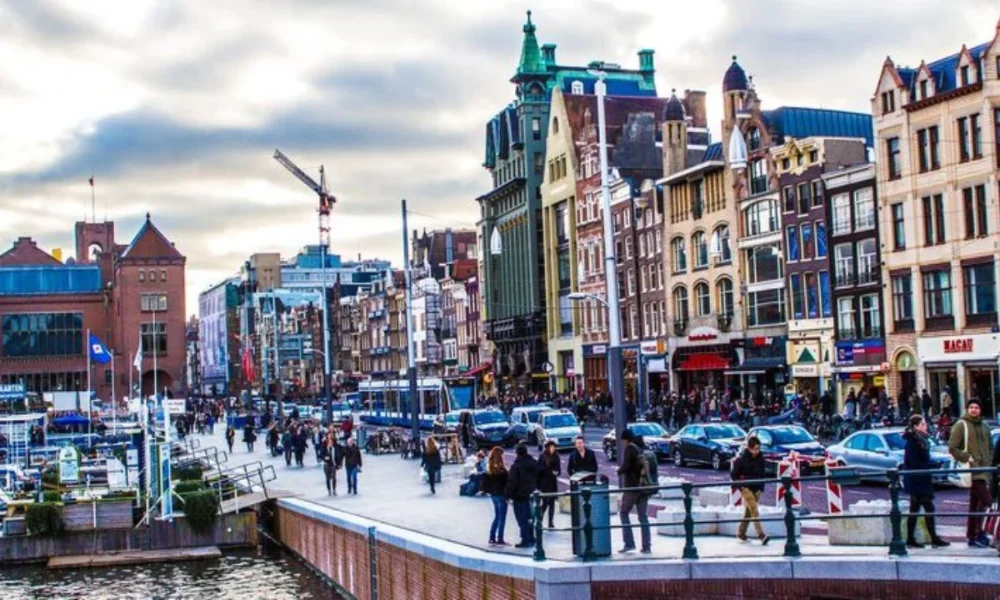 Busy Amsterdam street with canal and historic buildings