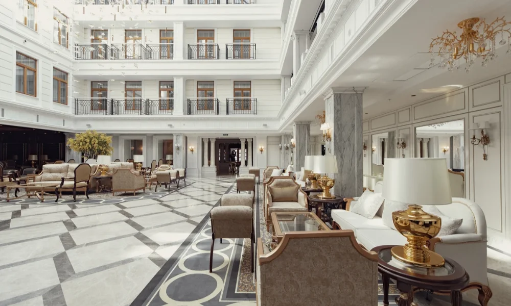 Grand hotel lobby with white walls, balconies, and ornate furniture.
