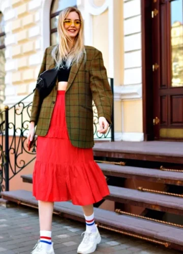Blonde woman in plaid blazer and red skirt