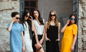 Five women in colorful dresses and sunglasses