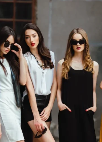 Five women in colorful dresses and sunglasses