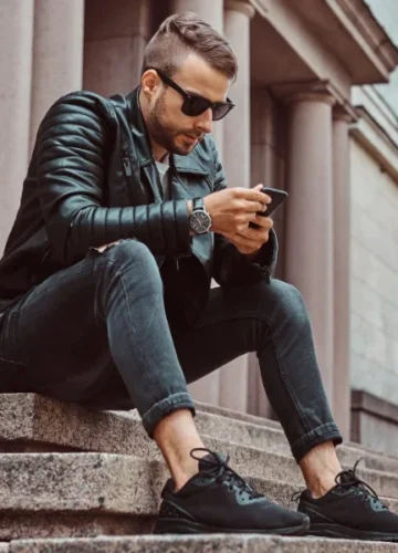 Man in black leather jacket and jeans on steps