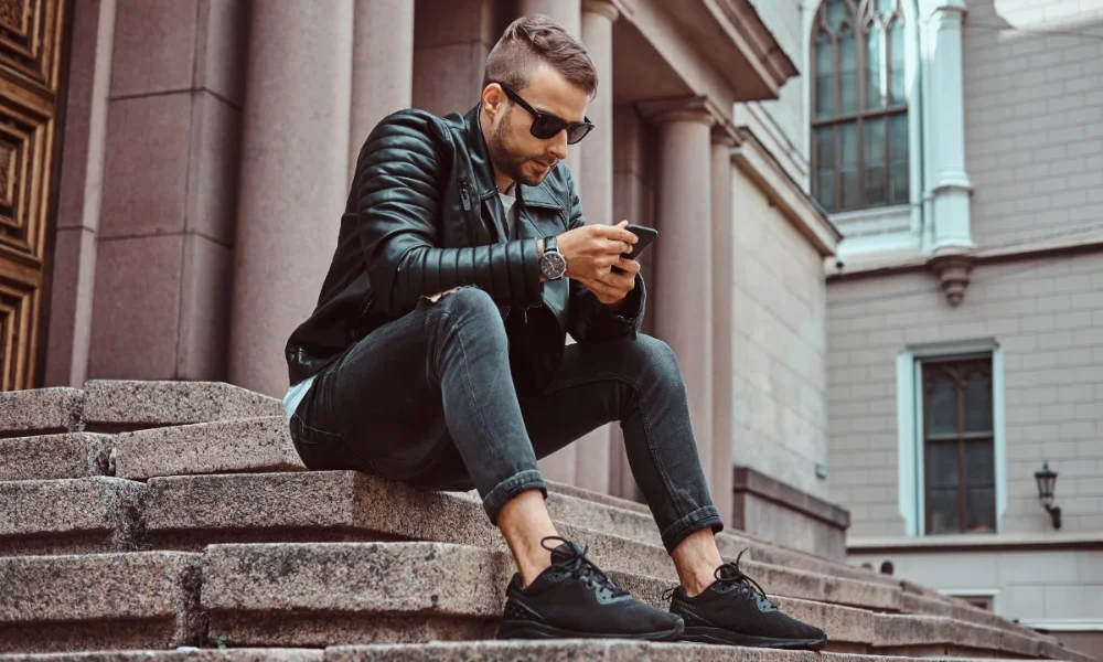 Man in black leather jacket and jeans on steps