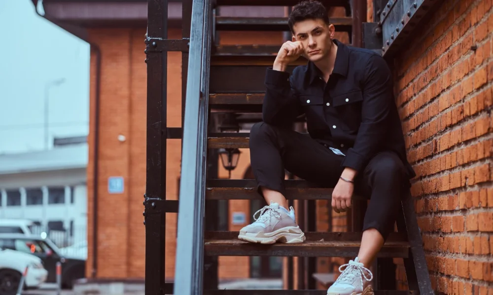 Man in black shirt and pants on metal stairs