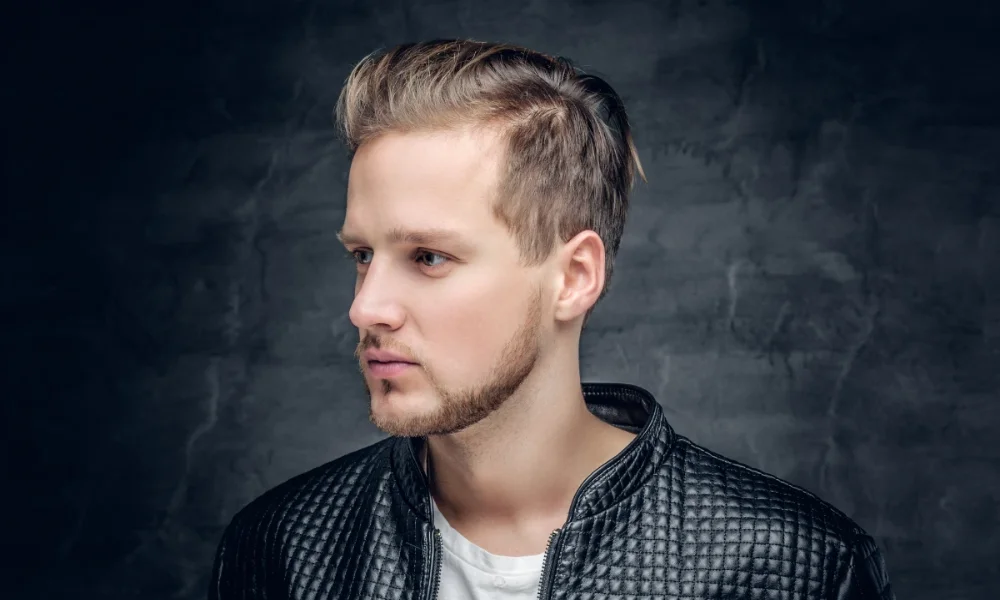 Man with blonde hair, beard, black jacket