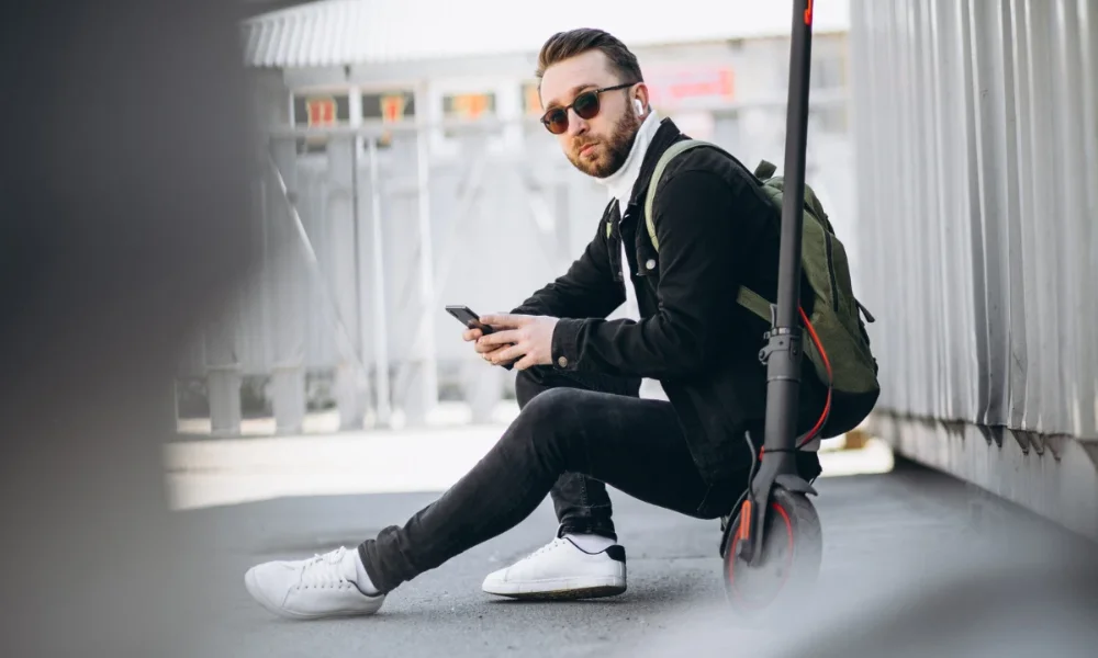 Man with scooter, phone, sunglasses, earbuds