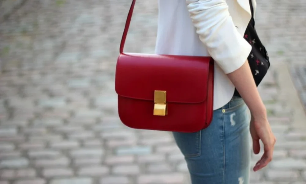 Person in white blazer, jeans, red purse
