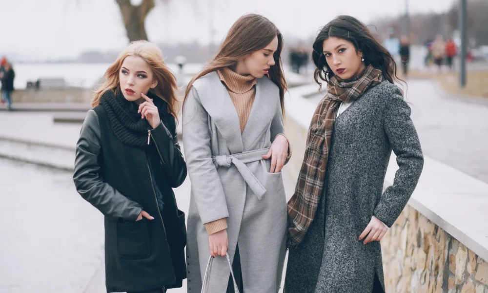 Three women in stylish winter coats outdoors