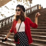 Woman in red shirt, polka dot skirt on stairs