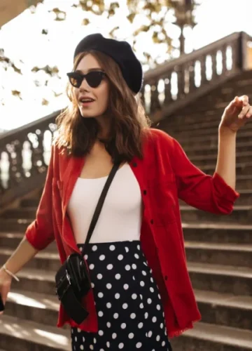 Woman in red shirt, polka dot skirt on stairs