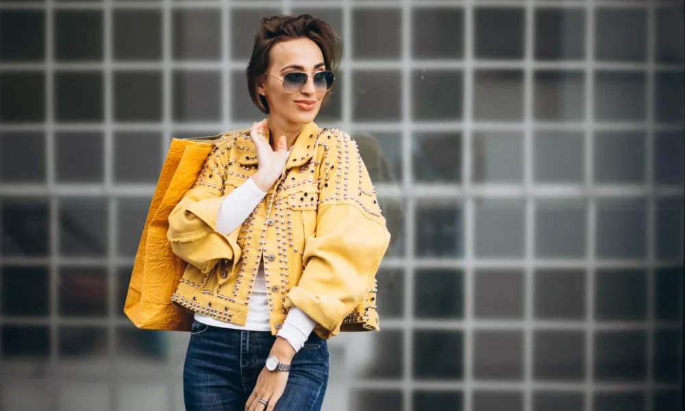 Woman in studded yellow jacket with shopping bag
