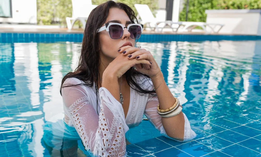 Woman in white dress and sunglasses in pool