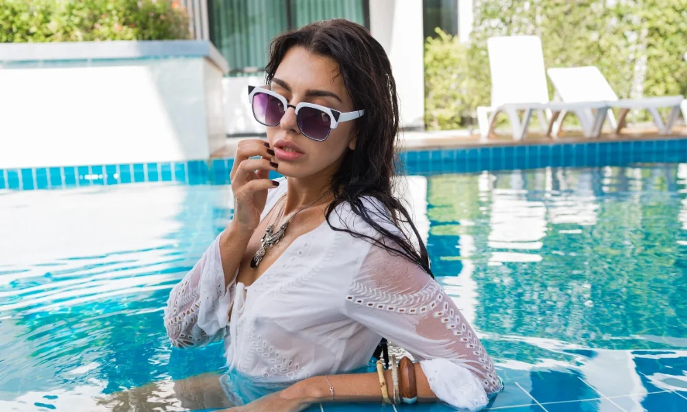 Woman in white shirt and sunglasses in pool