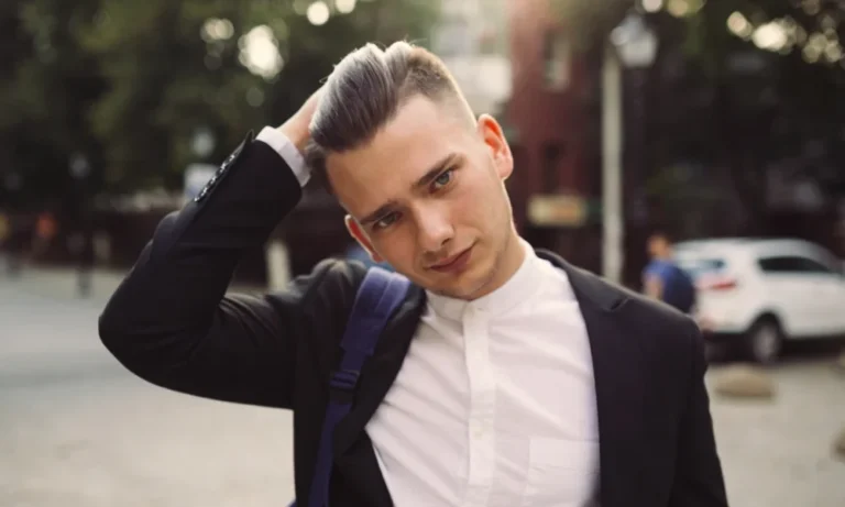 Young man in suit, hand on head, street