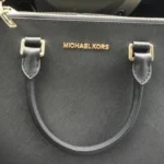 Black Michael Kors handbag with gold lettering