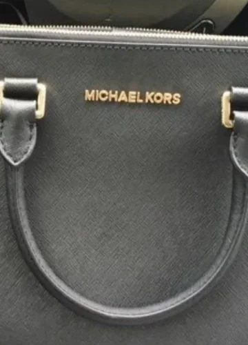 Black Michael Kors handbag with gold lettering