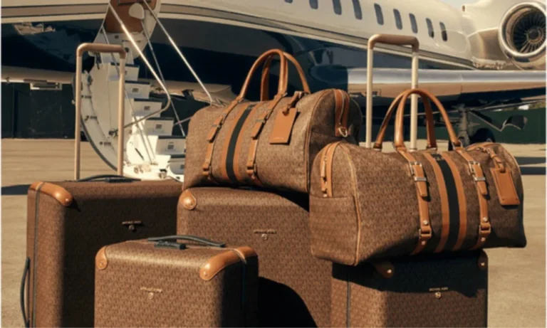 Brown Michael Kors luggage in front of a private jet