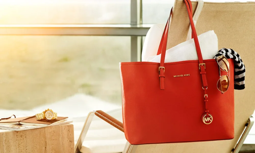 Red Michael Kors tote bag on a lounge chair
