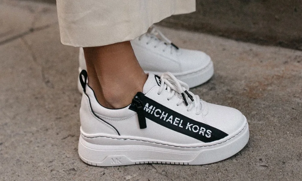 White Michael Kors sneakers on concrete