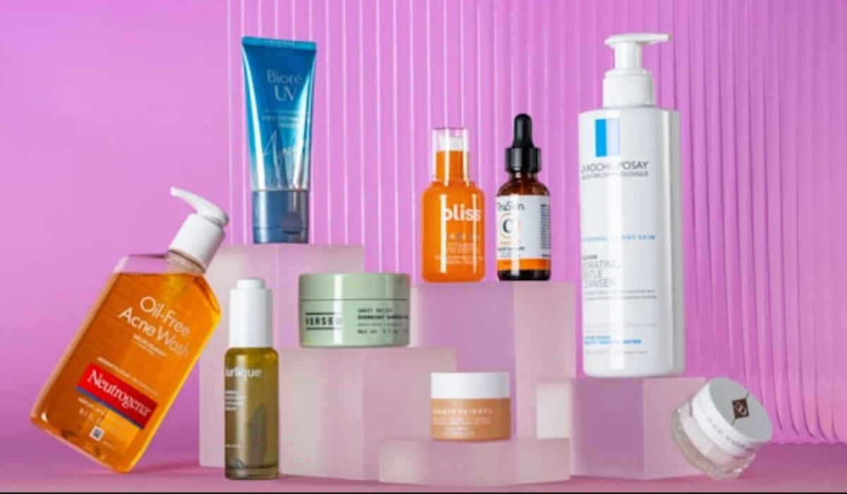 Assorted skincare products displayed on pink background