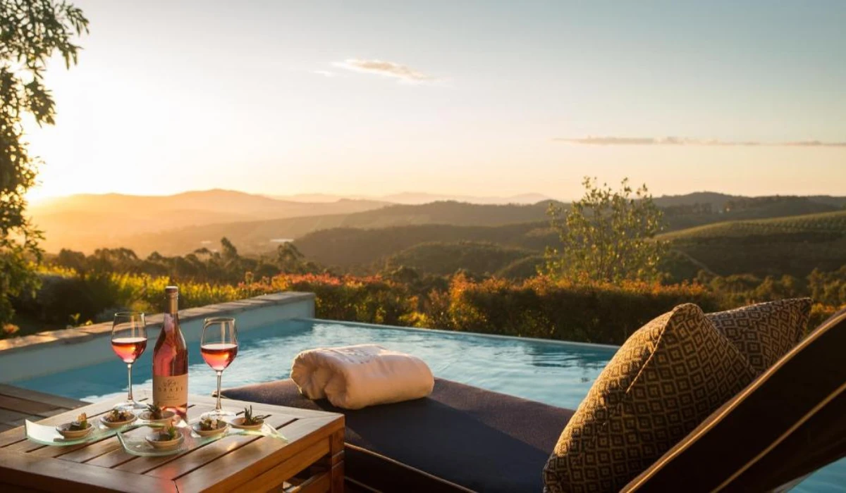 Luxury poolside wine setup with scenic sunset landscape