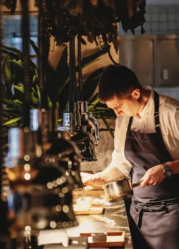 Chef plating food in a modern kitchen