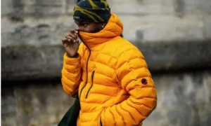 Man in orange puffer jacket and beanie