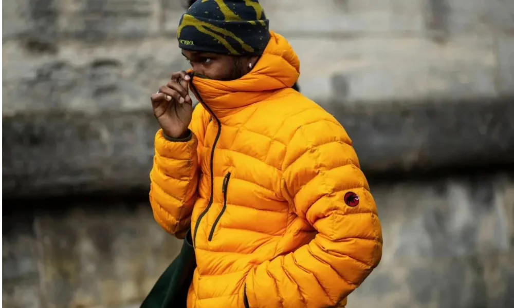 Man in orange puffer jacket and beanie