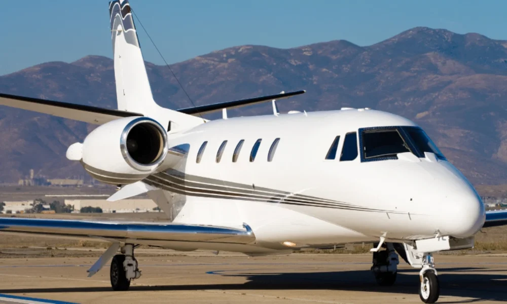 White private jet on tarmac, mountains