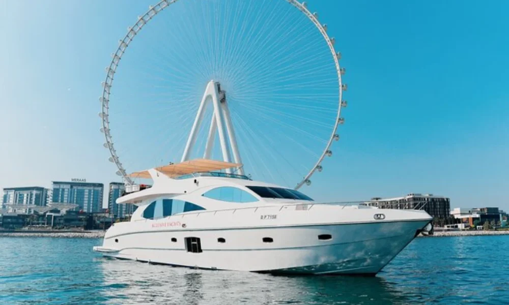 White yacht on water, Ferris wheel behind