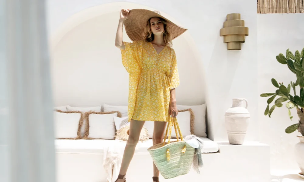 Woman in yellow kaftan and straw hat with bag