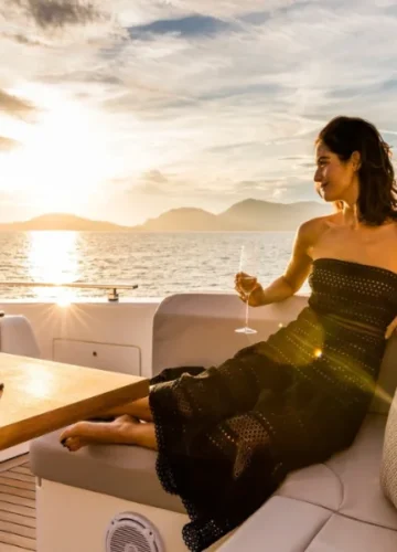 Woman on yacht at sunset with champagne