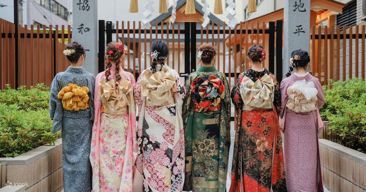 Back view of women in traditional Japanese floral kimonos with large decorative obi belts