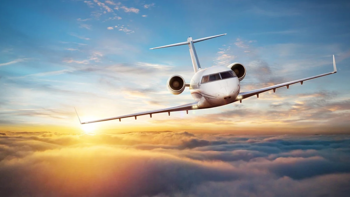 Sleek white luxury personal jet cruising smoothly through gold sunset clouds