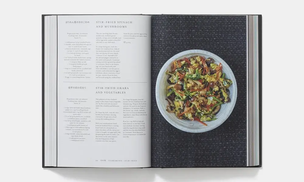 Open cookbook showing a colorful salad in a white bowl on the right and recipe text on the left, with a clean, elegant food-photography style.