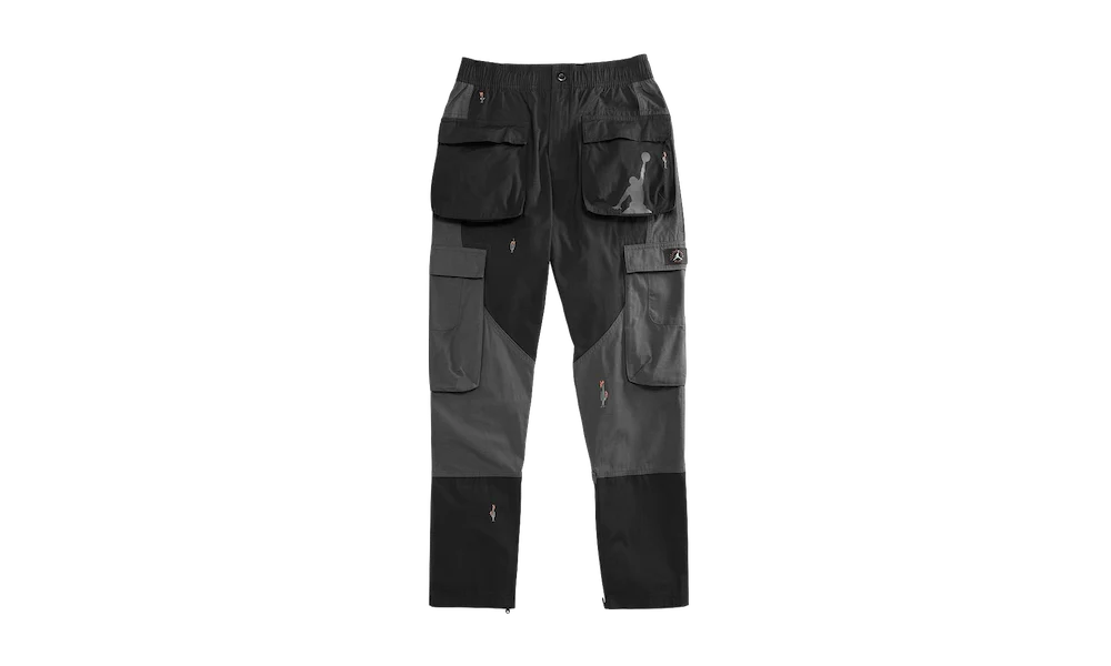 Black and charcoal-gray cargo work pants with reinforced knee panels, multiple flap pockets, and a relaxed fit, shown against a plain black background.