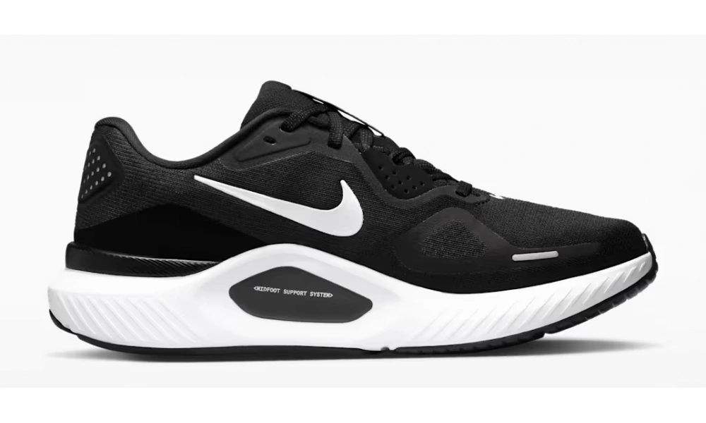 Side view of a black Nike running shoe with a white swoosh and thick, sculpted white sole, isolated on a light background; sleek, sporty design.