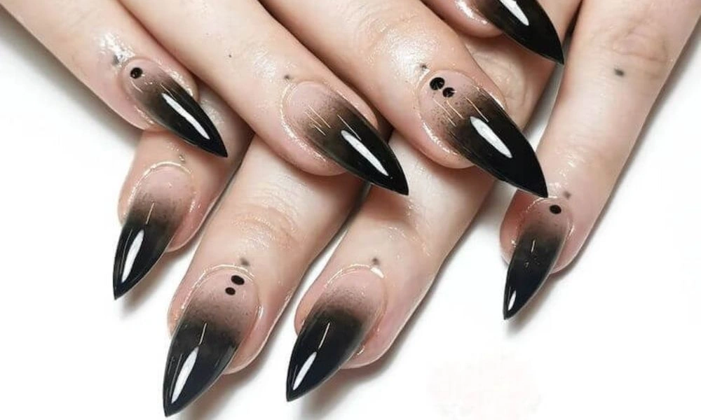 Close-up of hands with long almond-shaped nude-to-black-Dark Chrome Nail Ideas