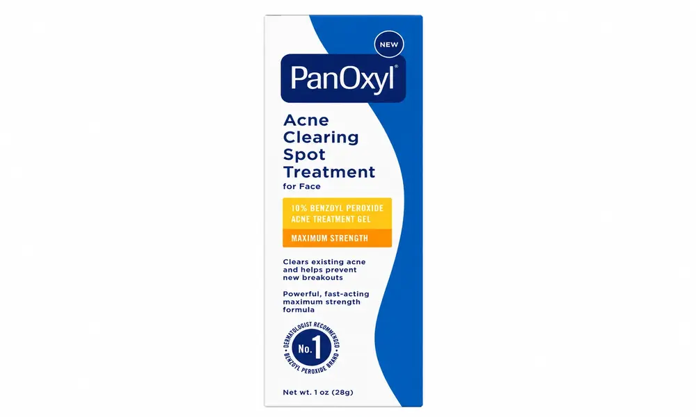PanOxyl Acne Clearing Spot Treatment for face in white and blue packaging with orange benefit labels, shown alone against a black background.